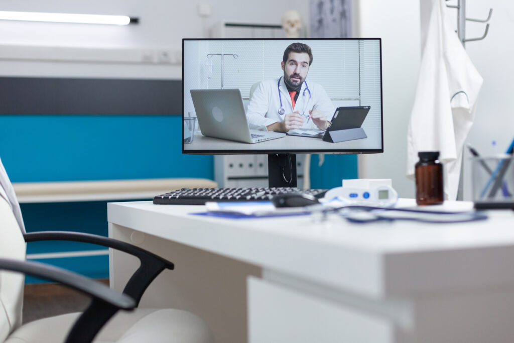 EZShifa Digital Clinic: The Smart Solution for Convenient Healthcare 2 computer screen with remote doctor having online videocall meeting conference standing table empty hospital office telework videoconference call medical consultation medicine concept 1